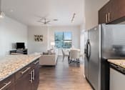 Thumbnail 8 of 20 - A modern kitchen with granite countertops and a refrigerator.